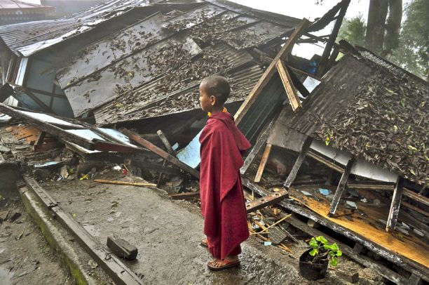 A young Buddhist monk looks on at a monastery damaged by an earthquake in Gangtok, India in September 2011. The earthquake int a remote Himalayan region damaged an estimated 100,000 homes.