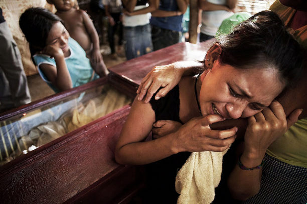 Family members weep over the body of a peasant killed in the Bajo Aguán community of Panamá in Honduras.