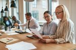 two-smiling-businesswomen-going-over-paperwork-at-LLDYSYA-1.jpg