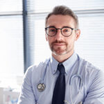 portrait-of-smiling-mature-male-doctor-with-stetho-J2MWQDT.jpg