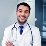 smiling-doctor-with-stethoscope-at-hospital-PVS8FJU.jpg